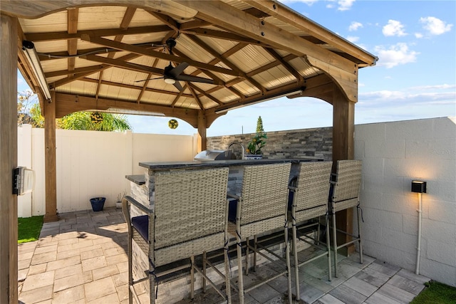 view of patio / terrace featuring a gazebo, outdoor wet bar, area for grilling, and fence