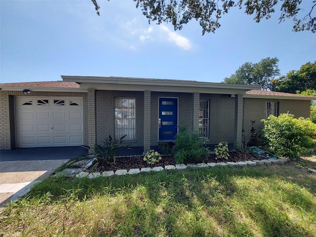 ranch-style home featuring concrete driveway, brick siding, and an attached garage