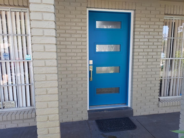 doorway to property featuring brick siding