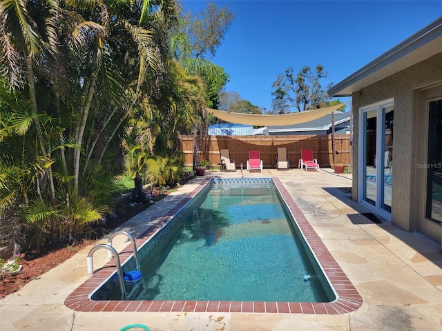 view of swimming pool featuring a fenced in pool, a patio area, and a fenced backyard