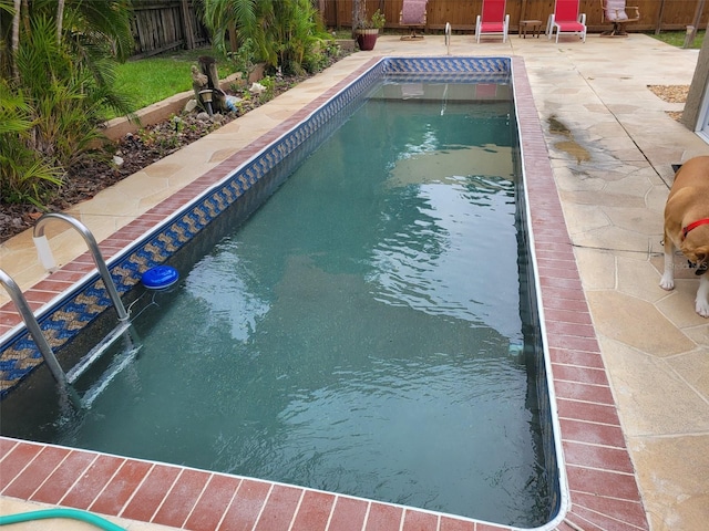 view of swimming pool featuring a patio, a fenced backyard, and a fenced in pool