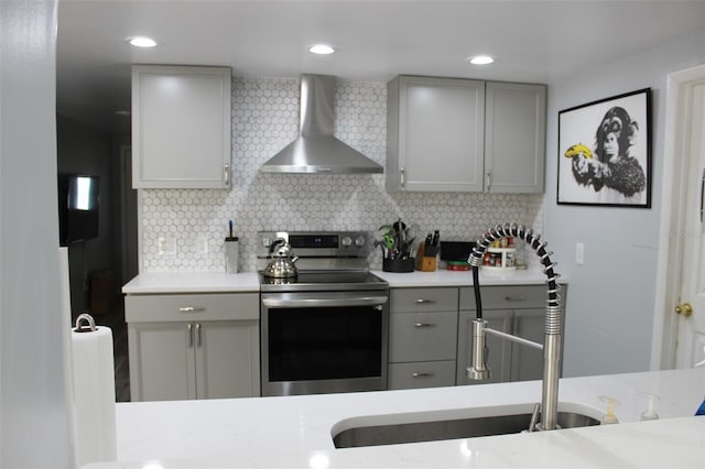 kitchen with electric stove, tasteful backsplash, wall chimney exhaust hood, and gray cabinets