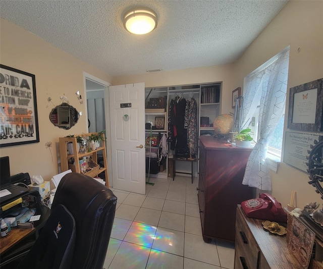 home office featuring visible vents, a textured ceiling, and light tile patterned flooring