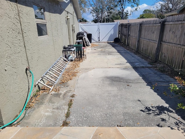 exterior space featuring a gate, fence, and a patio