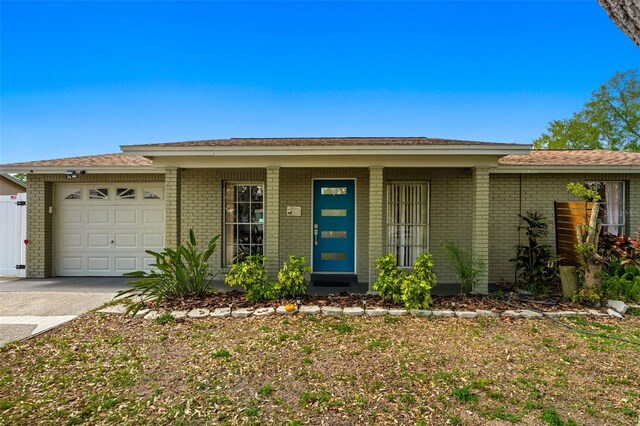 ranch-style home with a garage, brick siding, and driveway
