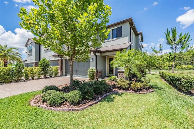 view of front of property with decorative driveway, a front yard, and stucco siding