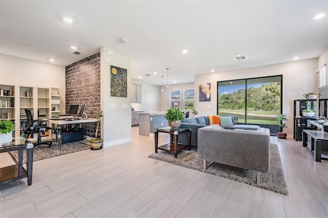 living area with baseboards, visible vents, and recessed lighting