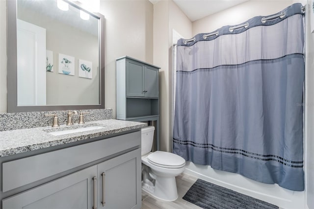 bathroom with shower / bathtub combination with curtain, vanity, and toilet