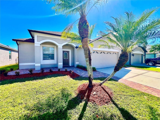 view of front of property featuring a garage, a front yard, driveway, and stucco siding