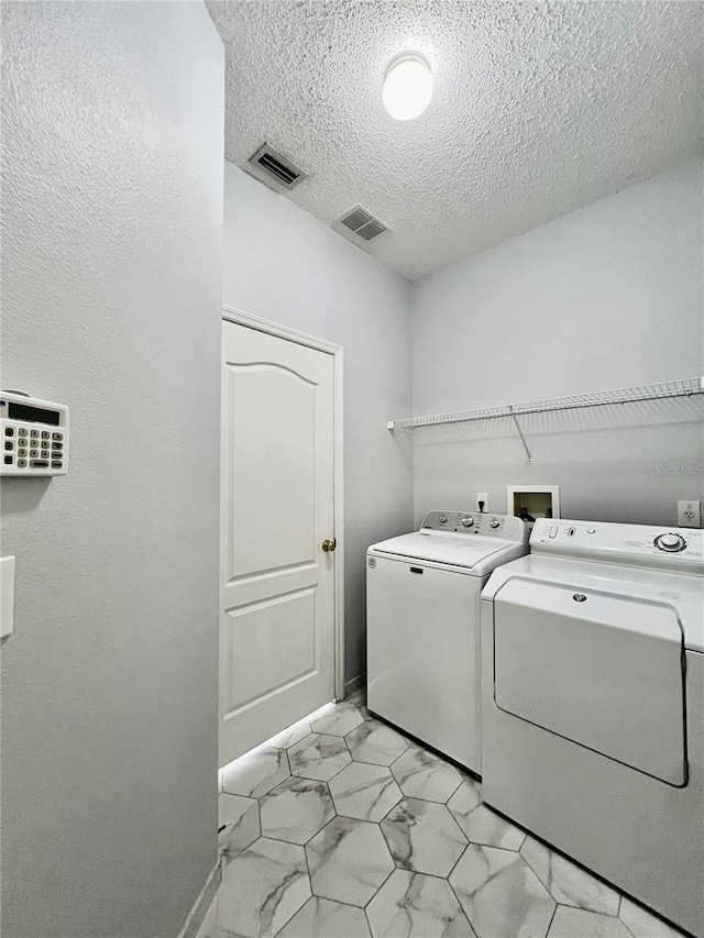 laundry room with laundry area, visible vents, marble finish floor, and separate washer and dryer