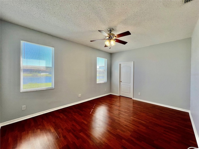 empty room featuring a ceiling fan, a textured ceiling, baseboards, and wood finished floors