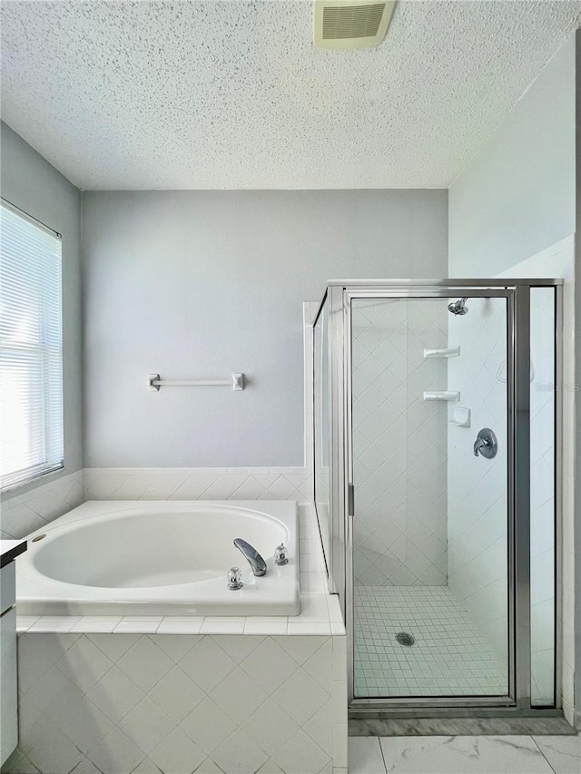 full bathroom featuring visible vents, a shower stall, a textured ceiling, and a bath