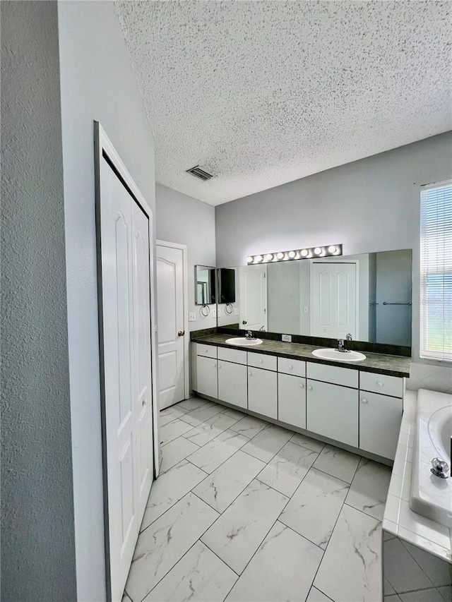 bathroom with double vanity, marble finish floor, and a sink