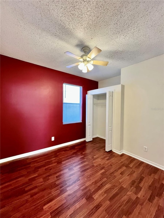 unfurnished bedroom featuring a textured ceiling, baseboards, and wood finished floors