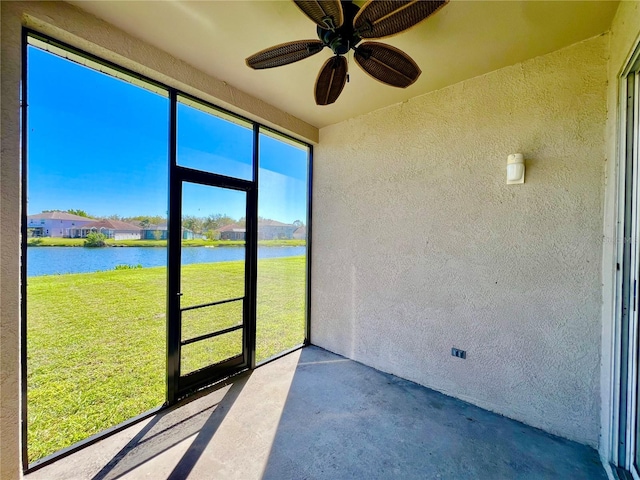 unfurnished sunroom with ceiling fan and a water view