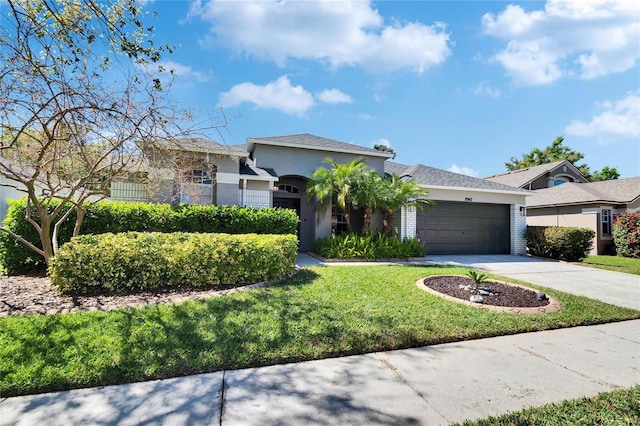 view of front of property featuring a garage, stucco siding, driveway, and a front lawn