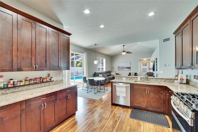 kitchen with visible vents, ceiling fan, open floor plan, stainless steel appliances, and a sink