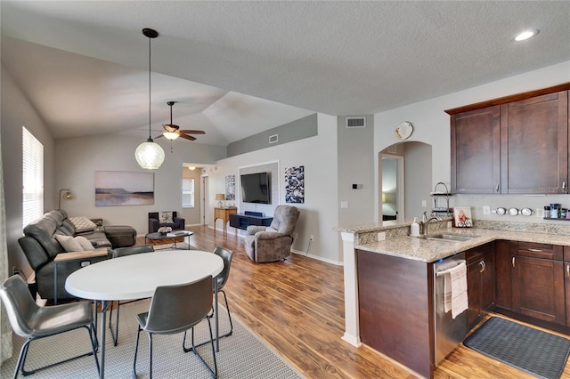 kitchen featuring a sink, visible vents, open floor plan, and a ceiling fan