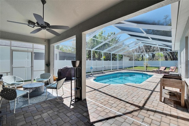 view of swimming pool with a patio, a ceiling fan, a fenced in pool, a fenced backyard, and a lanai