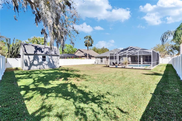 view of yard with a fenced in pool, a shed, glass enclosure, an outdoor structure, and a fenced backyard