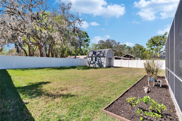 view of yard with a storage shed, an outbuilding, a fenced backyard, and a lanai