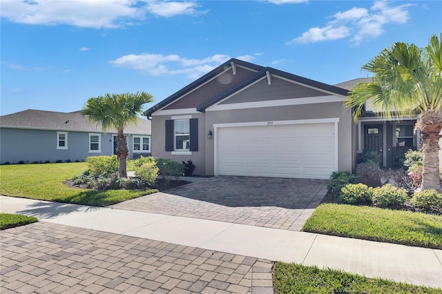 ranch-style home featuring decorative driveway, an attached garage, stucco siding, and a front yard