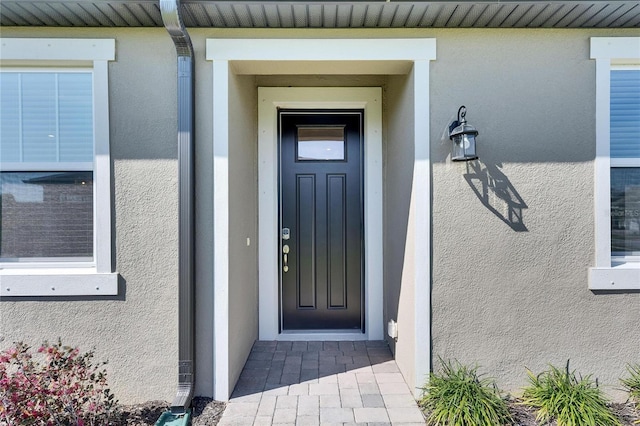 view of exterior entry featuring stucco siding