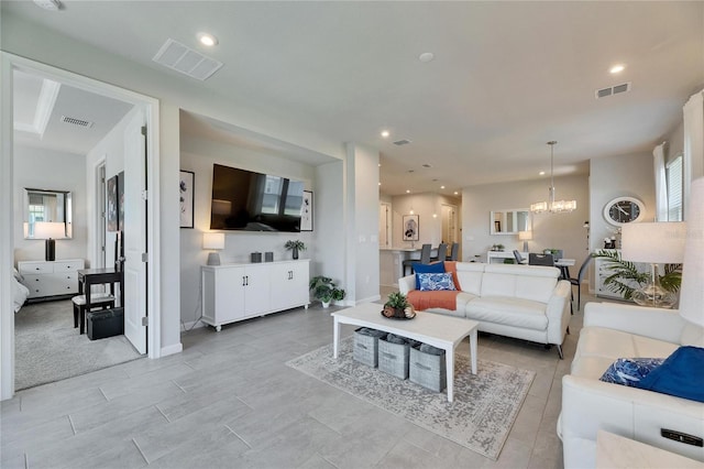 living area with recessed lighting, visible vents, and an inviting chandelier