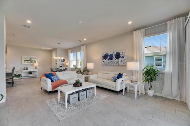 living area with visible vents, a notable chandelier, and recessed lighting