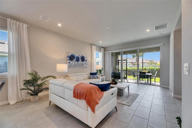 living room with recessed lighting, visible vents, and baseboards