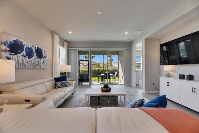 living area featuring baseboards, visible vents, and recessed lighting