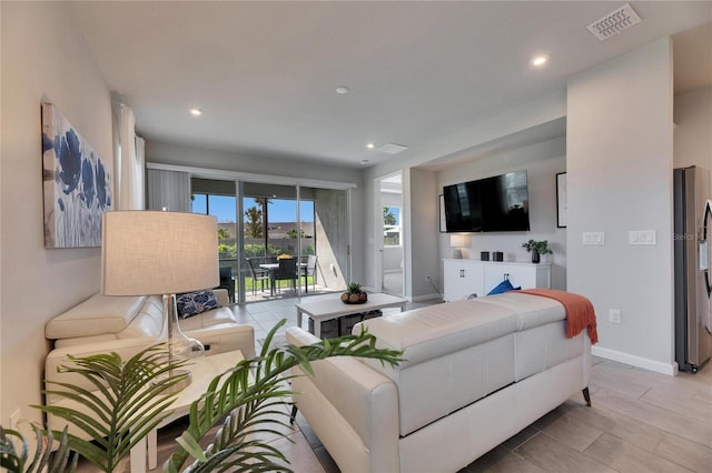 living room with light wood-type flooring, baseboards, visible vents, and recessed lighting