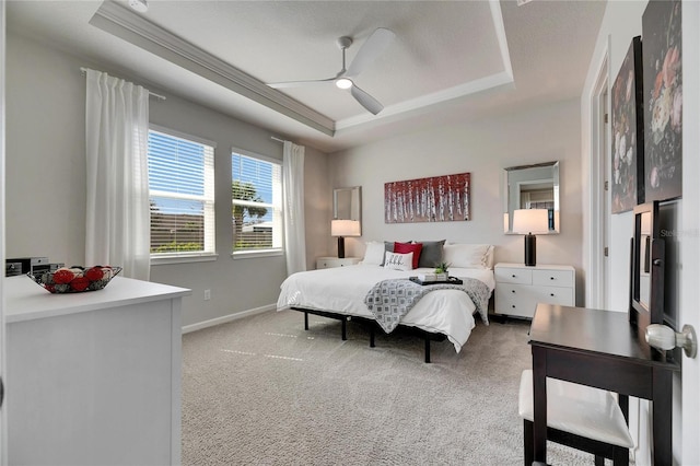 bedroom with a raised ceiling, light carpet, crown molding, and baseboards