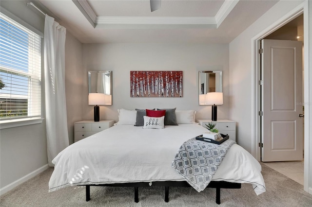 carpeted bedroom featuring ornamental molding, a raised ceiling, multiple windows, and baseboards