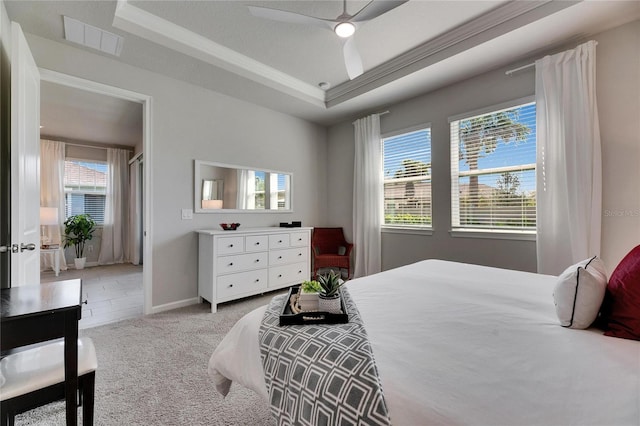 bedroom featuring light carpet, visible vents, baseboards, ceiling fan, and a tray ceiling