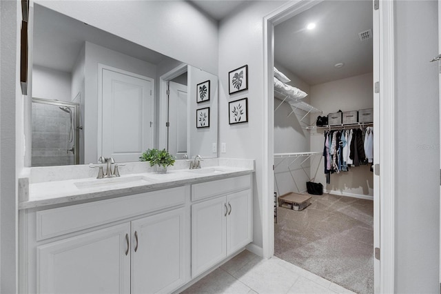 full bath featuring visible vents, a sink, a spacious closet, and double vanity