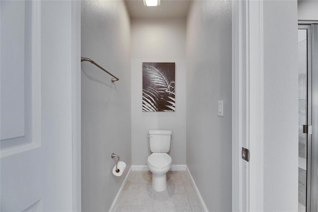 bathroom with a shower, baseboards, toilet, and tile patterned floors