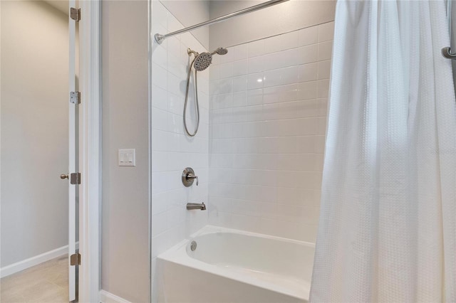 bathroom with baseboards and shower / tub combo with curtain