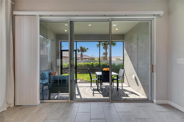 doorway to outside featuring wood tiled floor and baseboards