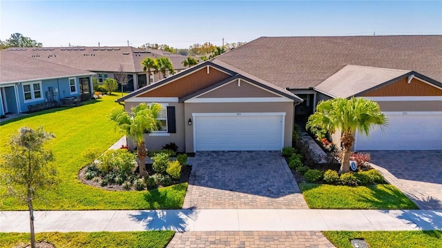 ranch-style home with an attached garage, stucco siding, decorative driveway, and a front yard