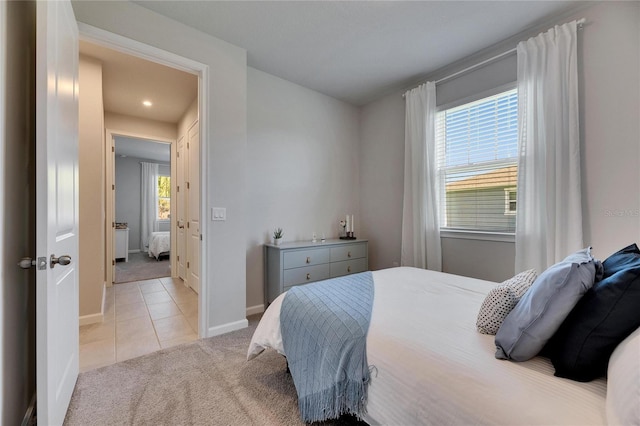 bedroom with light carpet, baseboards, and light tile patterned floors