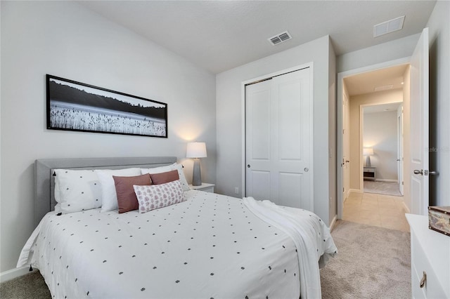 bedroom featuring light carpet, baseboards, visible vents, and a closet