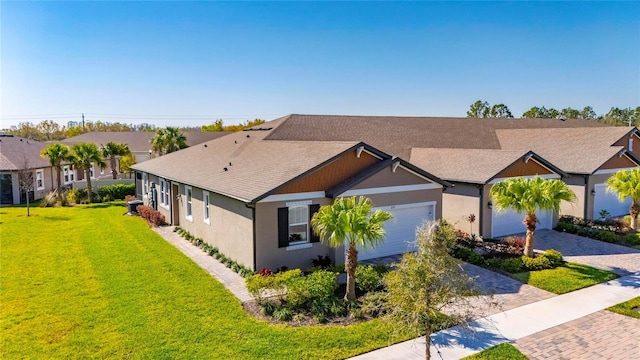 single story home with a garage, decorative driveway, a front lawn, and stucco siding