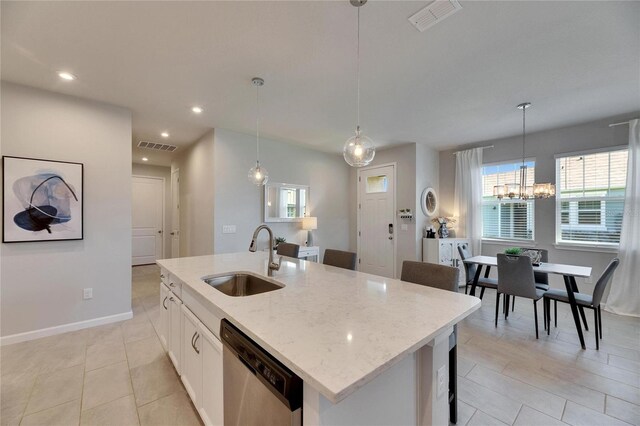 3753 Maxwell Park Dr, Sun City Center, FL 33573 - kitchen with stainless steel dishwasher, a sink, a kitchen island with sink, light stone counters, and white cabinetry