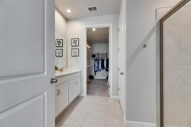 3753 Maxwell Park Dr, Sun City Center, FL 33573 - bathroom with a walk in closet, vanity, a shower stall, tile patterned floors, and recessed lighting
