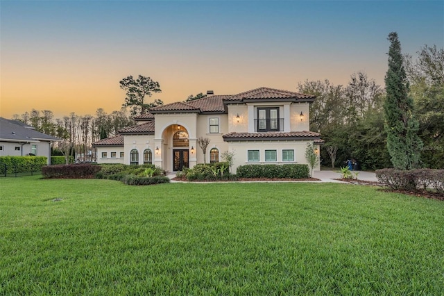 5914 Fitzgerald Rd, Odessa, FL 33556 - mediterranean / spanish house featuring french doors, stucco siding, a tile roof, and a front lawn
