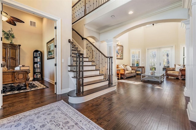 5914 Fitzgerald Rd, Odessa, FL 33556 - foyer with a towering ceiling, arched walkways, dark wood-style floors, ornate columns, and french doors