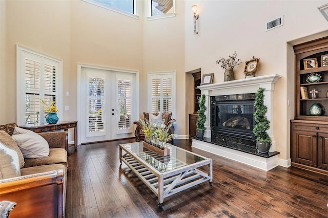 5914 Fitzgerald Rd, Odessa, FL 33556 - living area with a fireplace, dark wood-type flooring, a towering ceiling, and french doors