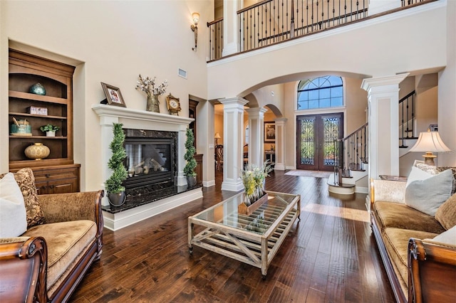 5914 Fitzgerald Rd, Odessa, FL 33556 - living room with arched walkways, ornate columns, a high ceiling, a fireplace, and stairs