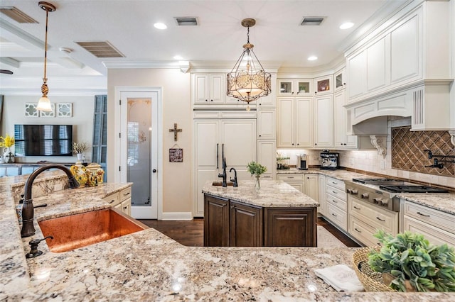 5914 Fitzgerald Rd, Odessa, FL 33556 - kitchen with a sink, stainless steel gas cooktop, light stone counters, ornamental molding, and backsplash